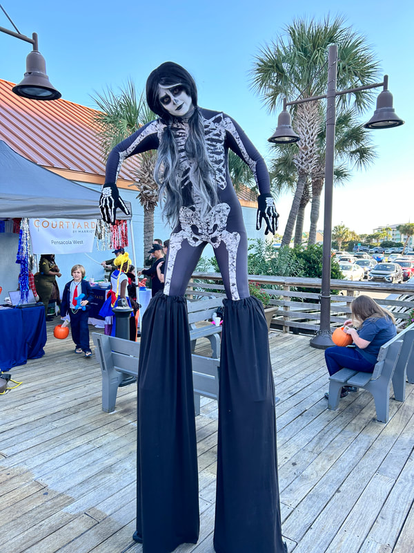 Flying with Ease entertainment silt walker performers. Stilt walkers, party performers, circus performers, entertainers, Pensacola Beach performers, Pensacola Performers, holiday performers, holiday entertainment, female stilt walker, holiday stilt walker, character stilt walker, Halloween stilt walker
